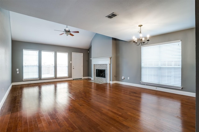 unfurnished living room featuring hardwood / wood-style flooring, a fireplace, ceiling fan with notable chandelier, and vaulted ceiling