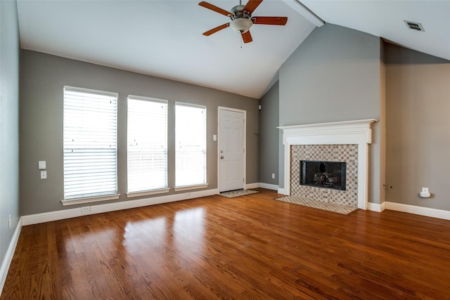 unfurnished living room featuring a tile fireplace, high vaulted ceiling, wood-type flooring, and ceiling fan