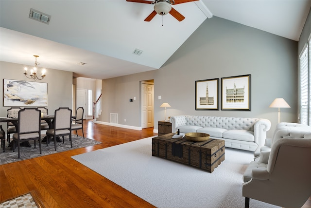 living room with hardwood / wood-style flooring, ceiling fan with notable chandelier, high vaulted ceiling, and beamed ceiling