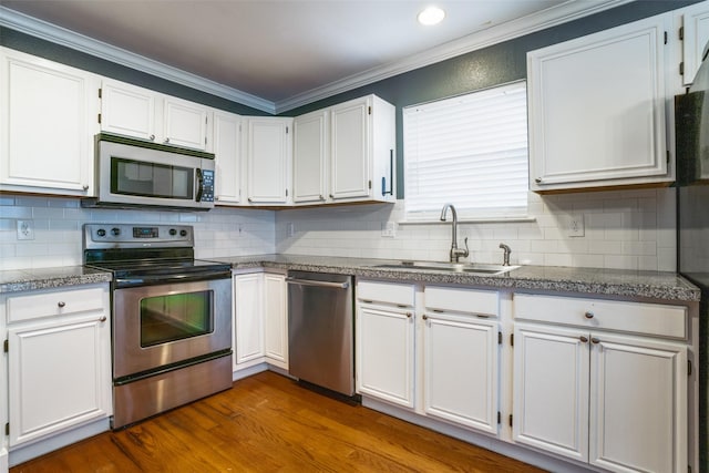 kitchen featuring dark wood-type flooring, sink, white cabinetry, crown molding, and appliances with stainless steel finishes