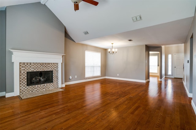 unfurnished living room featuring a tiled fireplace, ceiling fan with notable chandelier, wood-type flooring, and high vaulted ceiling