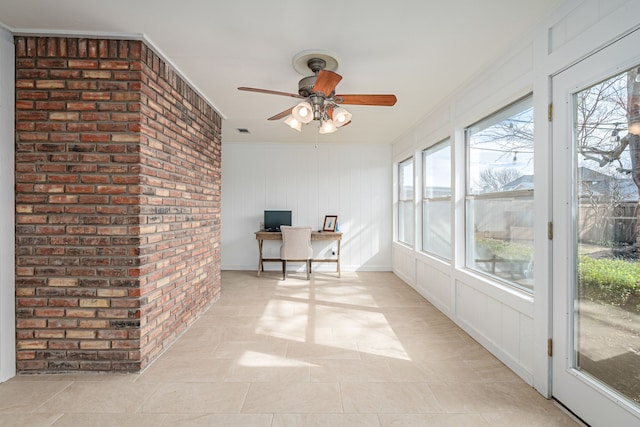 unfurnished sunroom featuring ceiling fan