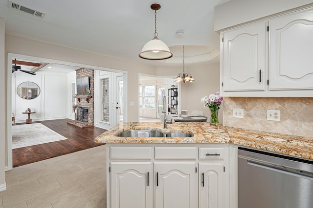 kitchen featuring white cabinetry, sink, stainless steel dishwasher, and kitchen peninsula