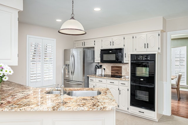 kitchen with sink, white cabinetry, tasteful backsplash, hanging light fixtures, and black appliances