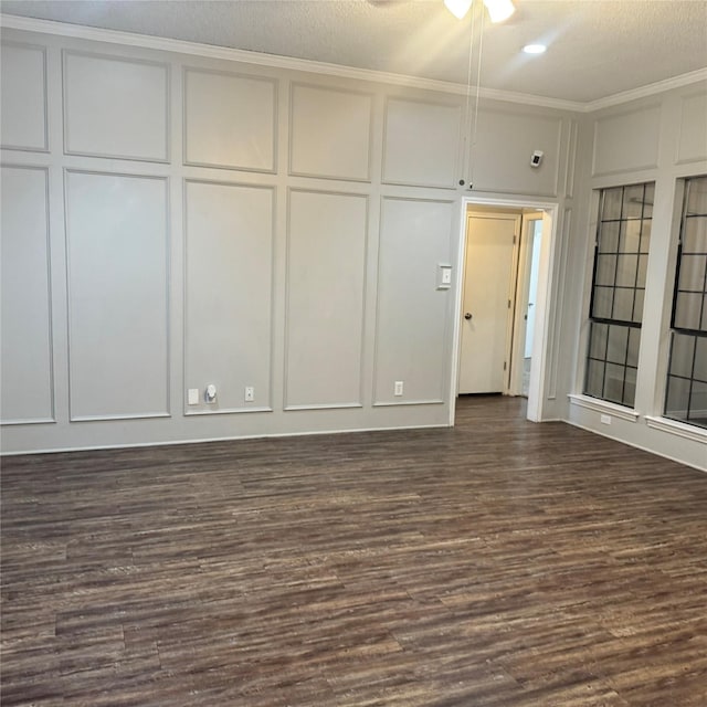 unfurnished room featuring dark wood-type flooring, ornamental molding, and a textured ceiling