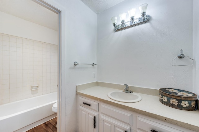 bathroom featuring vanity, hardwood / wood-style floors, a textured ceiling, and toilet