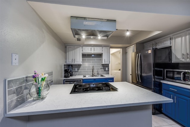 kitchen with appliances with stainless steel finishes, blue cabinets, sink, backsplash, and light tile patterned floors