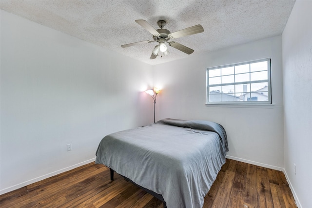 bedroom featuring ceiling fan, dark wood-type flooring, and a textured ceiling