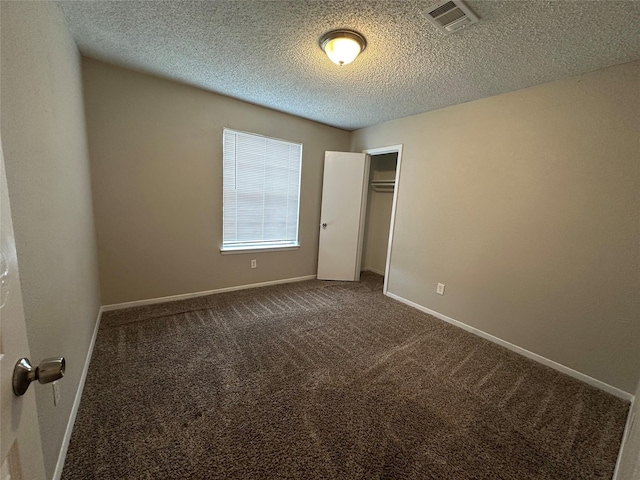 unfurnished bedroom featuring carpet, a textured ceiling, and a closet