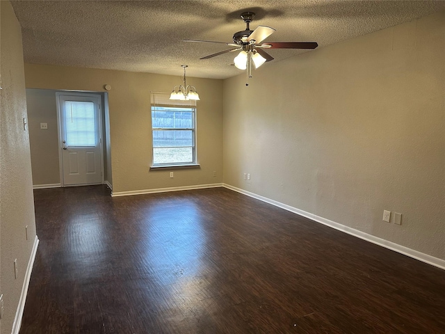 empty room with dark hardwood / wood-style flooring, ceiling fan with notable chandelier, and a textured ceiling