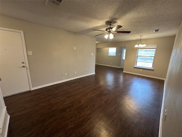 unfurnished room with ceiling fan with notable chandelier, dark hardwood / wood-style floors, and a textured ceiling