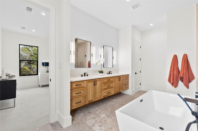 bathroom featuring vanity, a bathing tub, and decorative backsplash