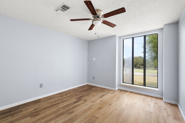 empty room featuring ceiling fan, light hardwood / wood-style floors, and a textured ceiling