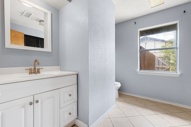 bathroom with vanity, tile patterned floors, a textured ceiling, and toilet