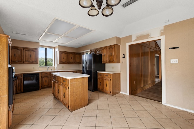 kitchen with sink, an inviting chandelier, a center island, black appliances, and light tile patterned flooring