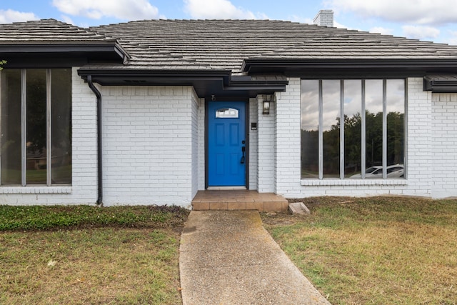 entrance to property with a lawn