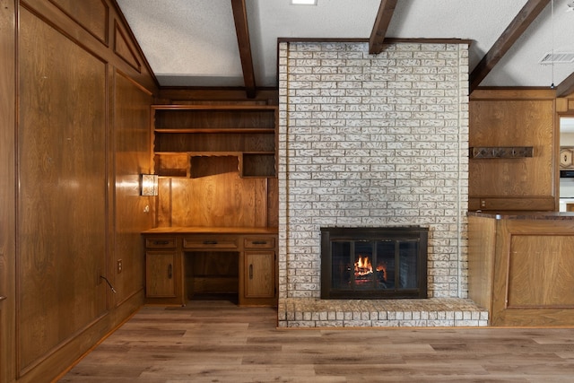 unfurnished living room with a textured ceiling and wood walls