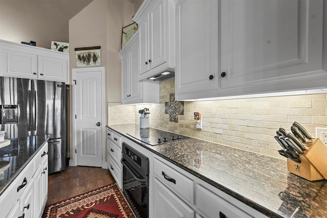 kitchen with black electric cooktop, stainless steel fridge, white cabinets, wall oven, and backsplash