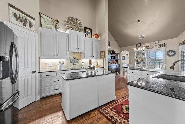 kitchen with sink, hanging light fixtures, a center island, stainless steel refrigerator with ice dispenser, and white cabinets