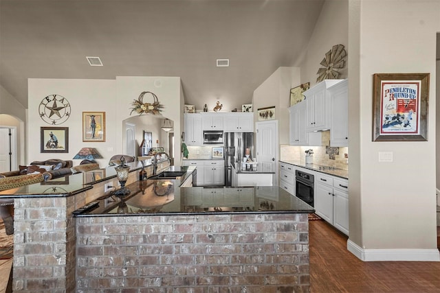 kitchen with sink, appliances with stainless steel finishes, white cabinetry, dark hardwood / wood-style flooring, and decorative backsplash