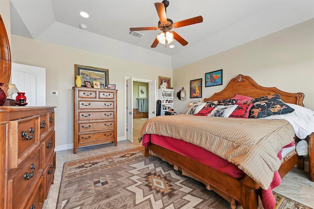 bedroom featuring ceiling fan, connected bathroom, a raised ceiling, and vaulted ceiling