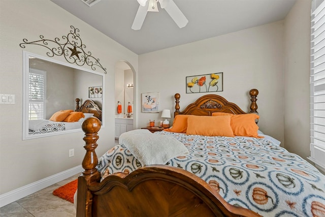 tiled bedroom featuring ceiling fan and ensuite bath