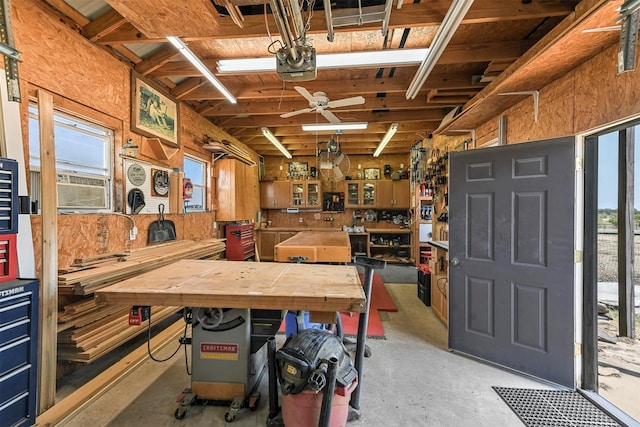 interior space with cooling unit, ceiling fan, and a workshop area