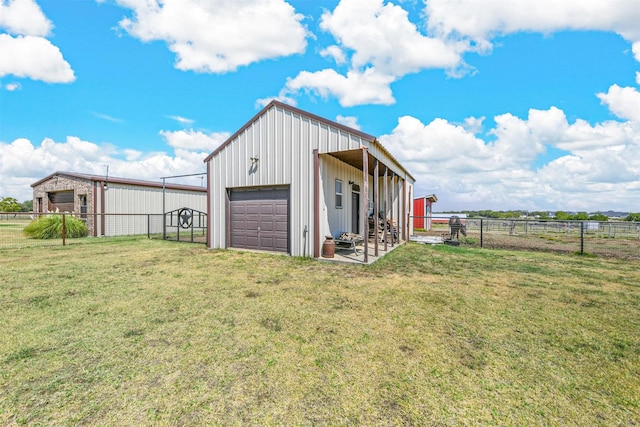 garage with a rural view and a yard