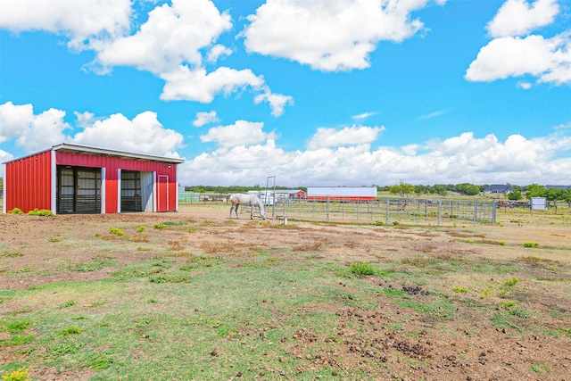 view of yard with an outbuilding and a rural view