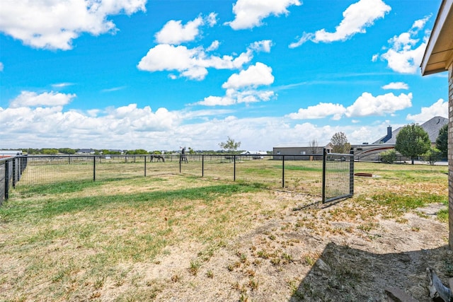 view of yard with an outdoor structure, an outbuilding, a rural view, and fence