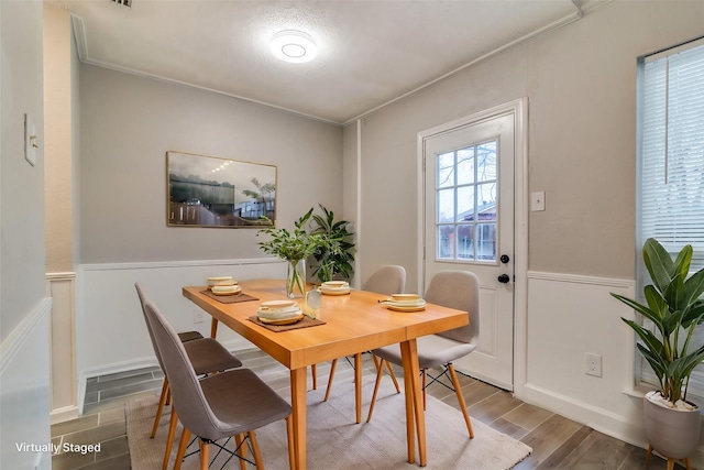 dining area with ornamental molding and wood-type flooring