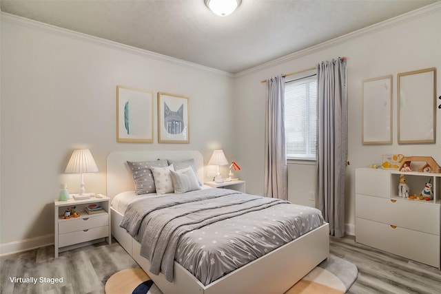 bedroom with crown molding and light hardwood / wood-style floors