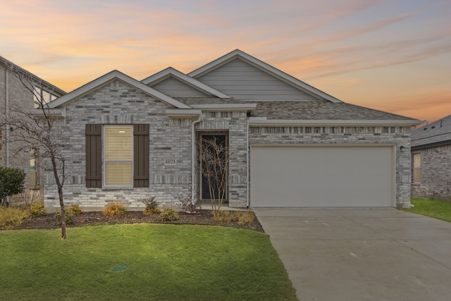 view of front facade with a garage and a yard