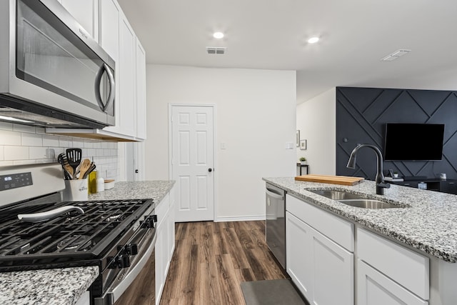 kitchen featuring white cabinetry, sink, light stone countertops, and appliances with stainless steel finishes