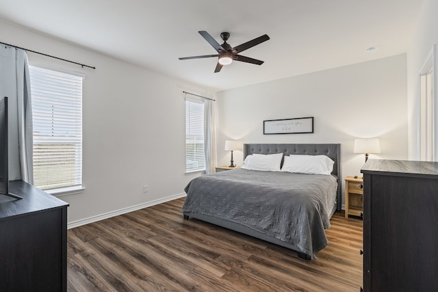 bedroom featuring ceiling fan, dark hardwood / wood-style flooring, and multiple windows