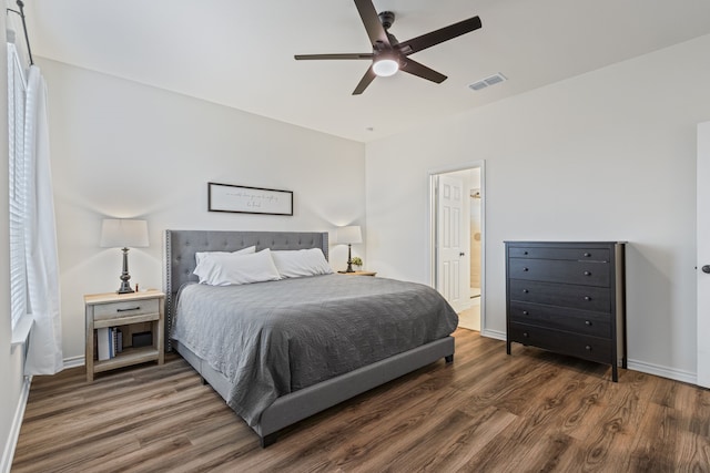 bedroom featuring ceiling fan, dark wood-type flooring, and ensuite bath