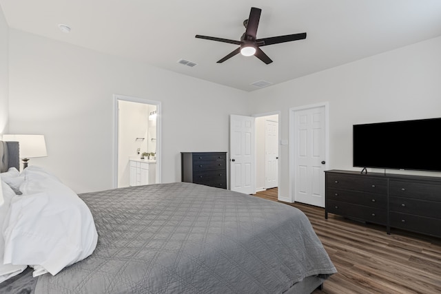 bedroom with ensuite bathroom, dark wood-type flooring, and ceiling fan