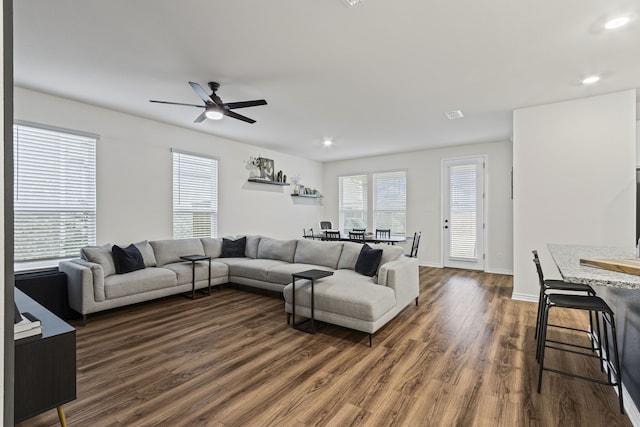 living room with dark wood-type flooring and ceiling fan