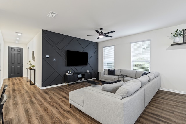 living room featuring dark wood-type flooring and ceiling fan