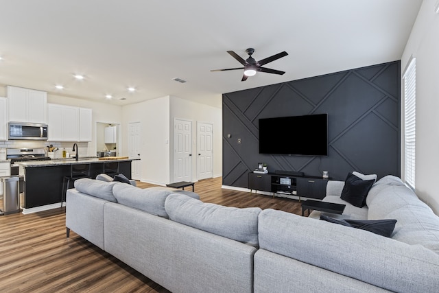 living room featuring ceiling fan, dark hardwood / wood-style flooring, and sink