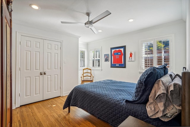 bedroom with crown molding, ceiling fan, light hardwood / wood-style floors, and a closet