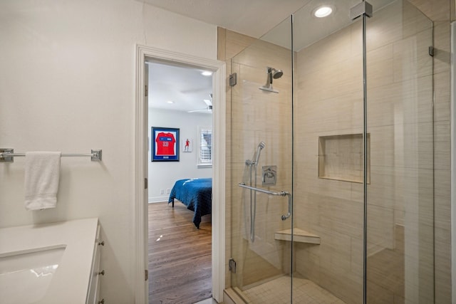 bathroom featuring vanity, hardwood / wood-style floors, and a shower with door