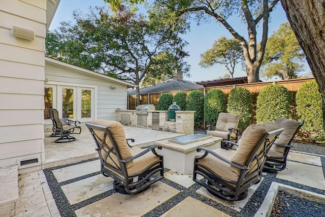 view of patio / terrace with a grill, a fire pit, and exterior kitchen