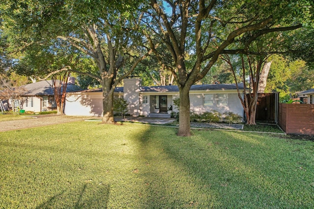 ranch-style house featuring a garage and a front lawn