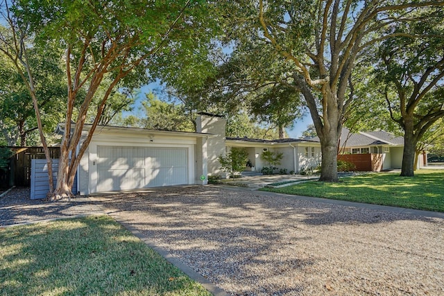 ranch-style home featuring a garage and a front lawn