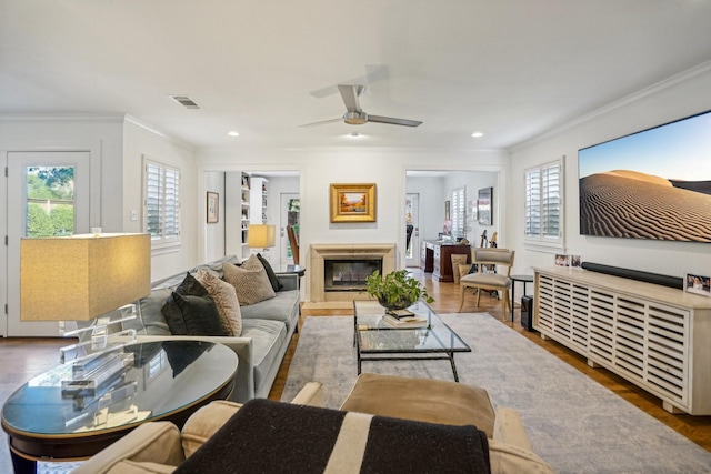 living room with hardwood / wood-style floors, crown molding, and plenty of natural light