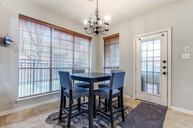 dining area with light tile patterned flooring, a wealth of natural light, and a chandelier