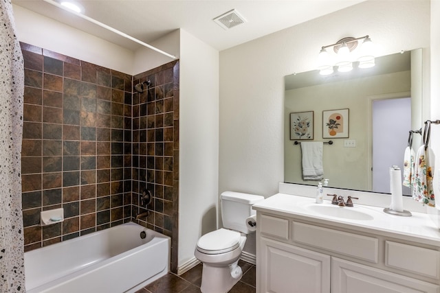 full bathroom with tiled shower / bath, vanity, tile patterned floors, and toilet