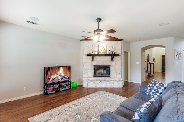 living room with ceiling fan, dark hardwood / wood-style floors, and a fireplace