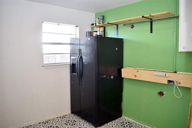 kitchen with black fridge with ice dispenser and green cabinetry